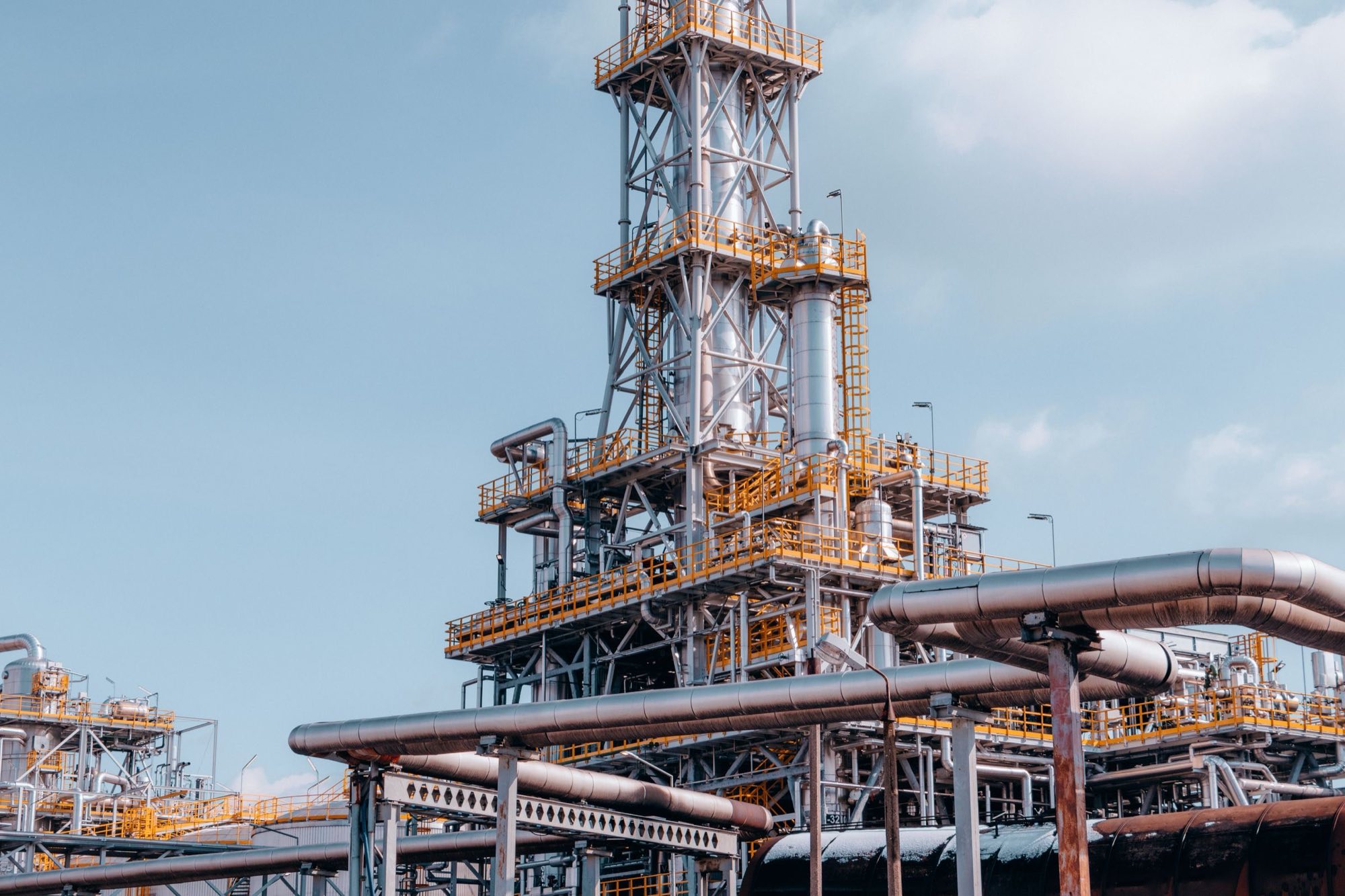 Process towers and pipe racks at a refinery under a clear sky